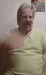 a man with a mustache is sitting on a couch in front of a camera .
