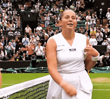 a woman on a tennis court wearing a white tank top that says oviva on it