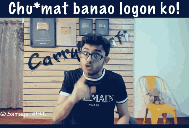 a man wearing glasses and a black shirt that says almain on it