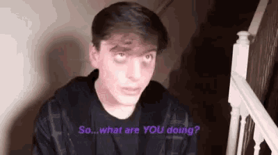 a young man is sitting on a set of stairs talking to someone .