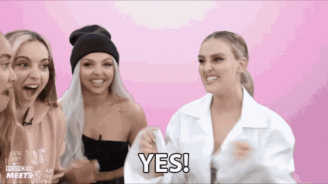 a group of women are sitting in front of a pink background and one of them is saying yes