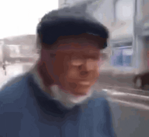 a blurry picture of a man wearing a hat and a blue sweater