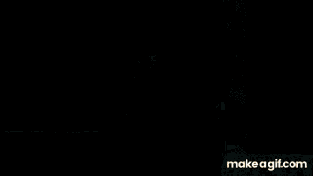 a person is standing in a dark room with a light coming out of the door .