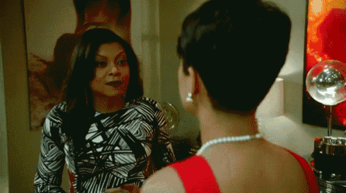 a woman in a red dress talks to another woman in a black and white dress