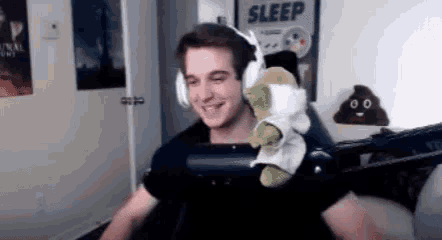 a man is wearing headphones and holding a stuffed animal in his lap .