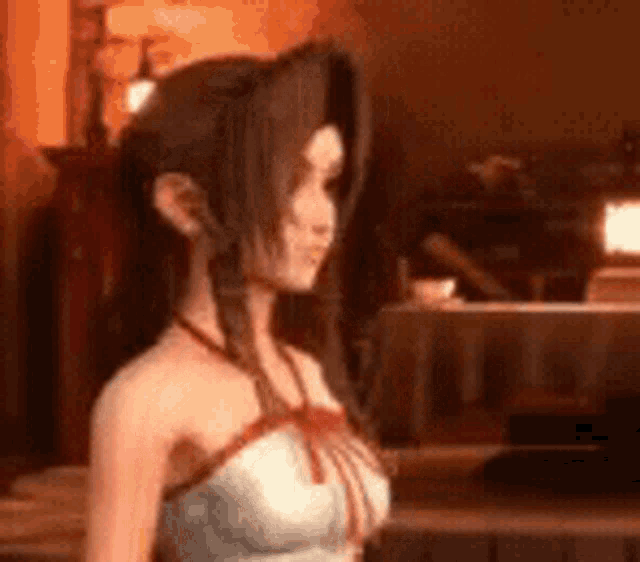 a woman in a white dress is standing in a room with a table in the background .
