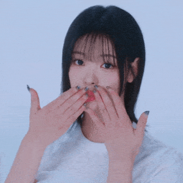 a girl with short black hair is smiling and making a funny face