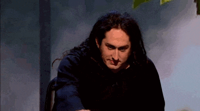 a man with long hair is sitting in a chair .