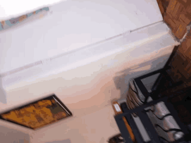 an aerial view of a room with a picture on the wall and stairs