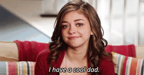 a woman is sitting on a couch and crying and saying `` i have a cool dad '' .