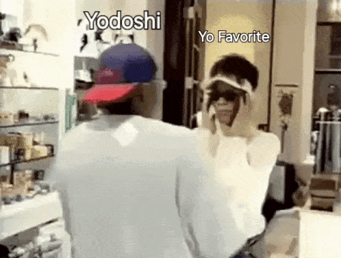 a man and a woman are standing in front of a mirror . the woman is wearing sunglasses and a hat .