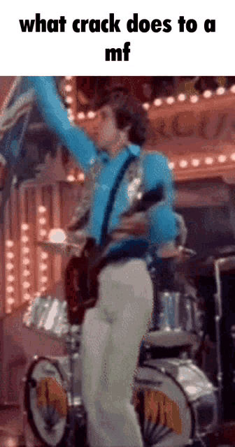 a man in a blue shirt is playing a guitar in front of a drum set with the words what crack does to a mf below