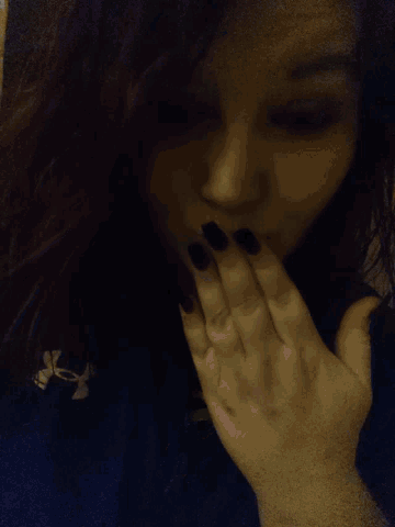 a person 's hand is touching another person 's face .