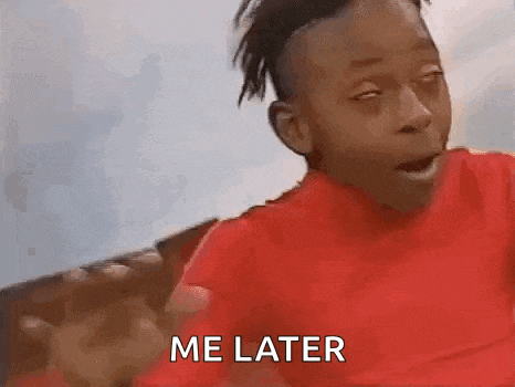 a young boy in a red shirt is sitting on a couch and making a funny face and saying `` me later '' .