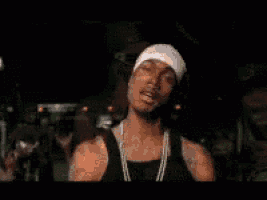 a man in a black tank top is standing in a crowd