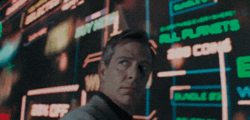 a man standing in front of a screen that says all planets