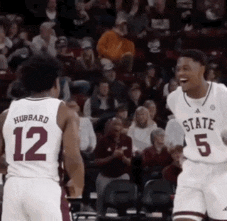 a basketball player with the number 12 on his jersey is talking to another player with the number 5 on his jersey