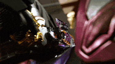 a close up of a purple and gold object with the letter l on it