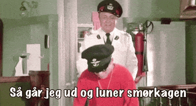 a man in a red shirt is standing next to a man in a black hat with the letter g on it ..