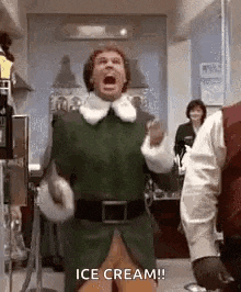 a man in a green elf costume is screaming and holding an ice cream cone in his hand .