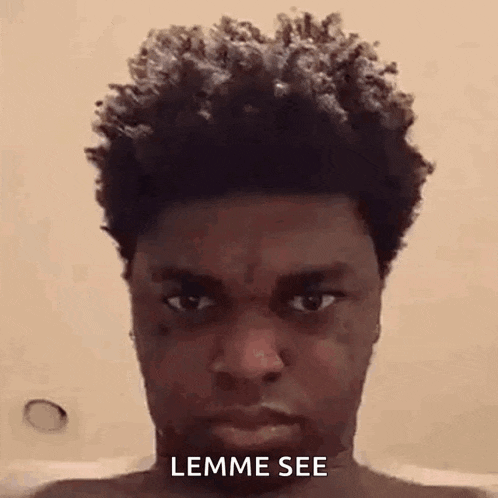 a man with curly hair is taking a selfie in a bathtub .