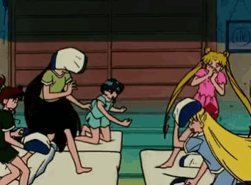 a group of cartoon characters are playing with pillows on a bed .