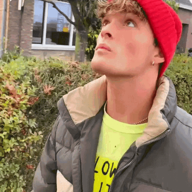 a man wearing a red beanie and a yellow shirt that says love