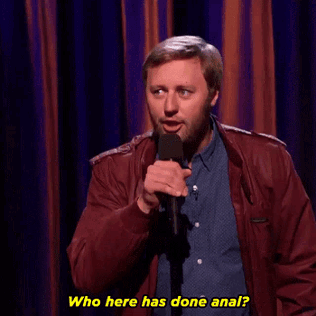 a man speaking into a microphone with the words " who here has done anal " written below him