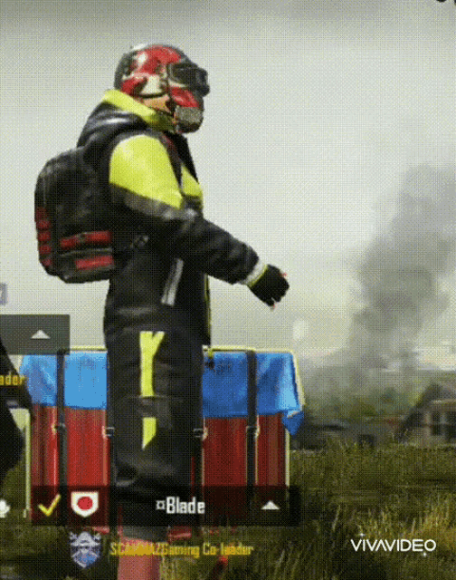 a man wearing a helmet and gloves is standing in a field next to a box that says blade on it
