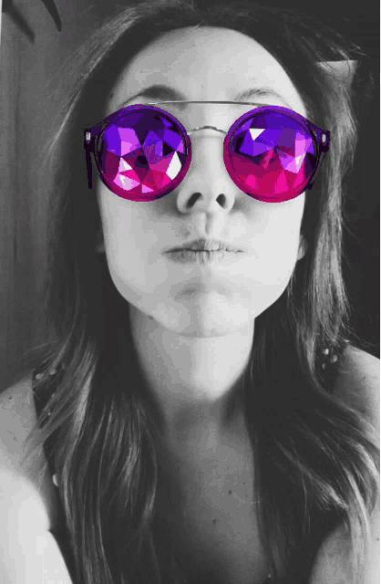 a woman wearing a pair of pink and purple sunglasses blowing a kiss