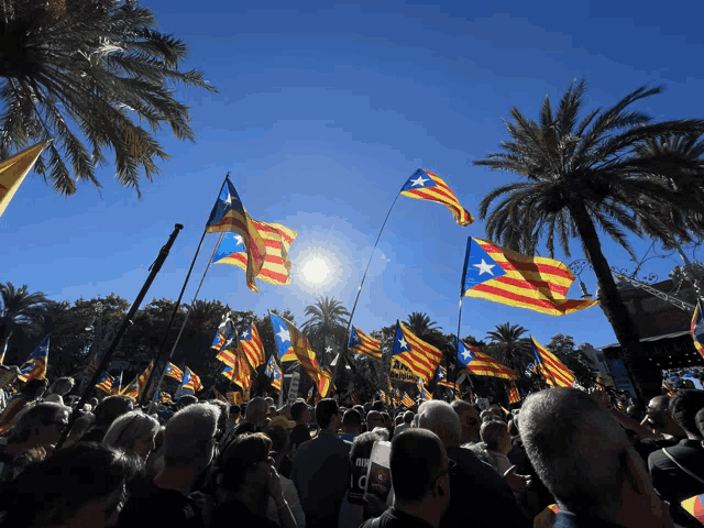 a crowd of people holding flags with one man wearing a shirt that says ' i love you '