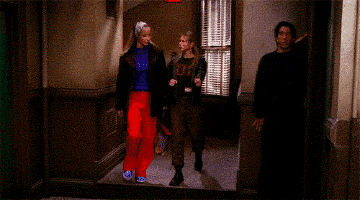 a group of people are standing in a hallway and one of them is wearing a shirt that says ' a '