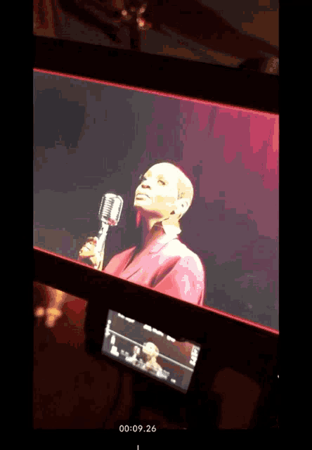 a woman singing into a microphone on a screen that says 00 : 09.26