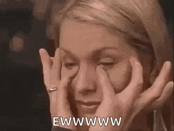 a woman is rubbing her eyes with her hands and making a funny face .