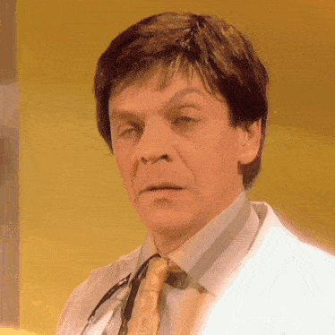 a close up of a man wearing a white coat and tie