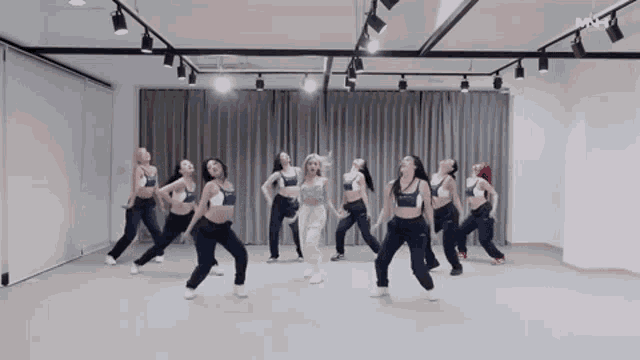 a group of women are dancing in a room with a white curtain .