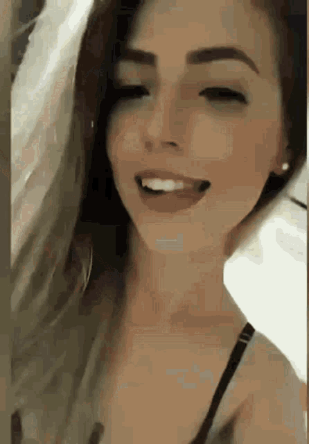 a close up of a woman 's face with her eyes closed and her tongue out .