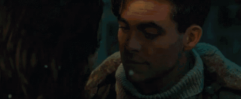 a man and a woman are looking into each other 's eyes in a dark room .