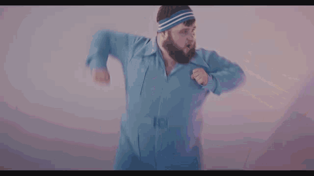 a man in a blue suit is doing a karate move