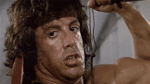 a man with sweat on his face is holding a sword in his hand