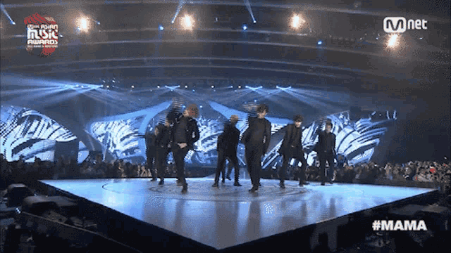 a group of people dancing on a stage with a mnet logo in the corner