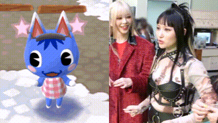 two women are standing next to each other next to a blue cat .