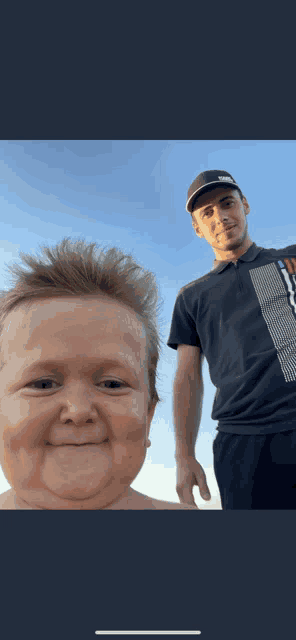 a man in a puma shirt stands next to a small child