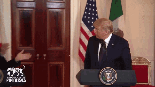 a man stands behind a podium that says republica de fifidonia on it