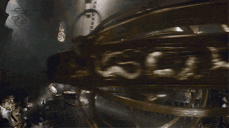 a dark room with a clock hanging from the ceiling and a light shining through the windows