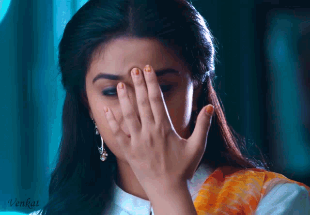 a woman is covering her face with her hand and the word venkat is visible in the corner