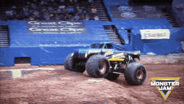 a monster jam truck is going down a dirt track