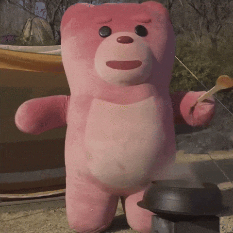 a pink teddy bear is standing next to a pot