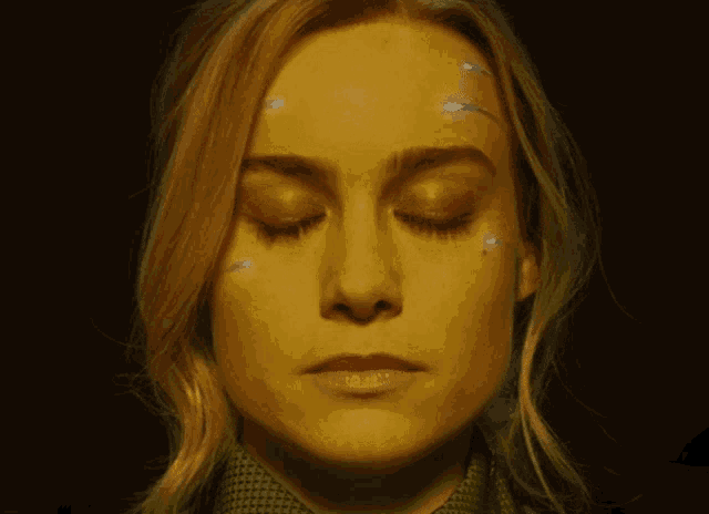 a close up of a woman 's face with yellow hair