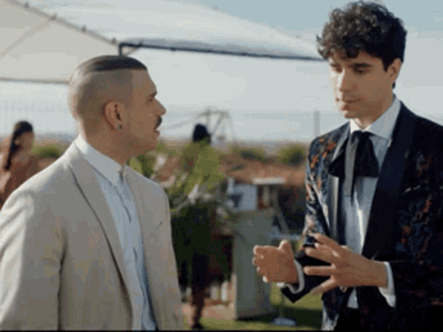 two men in suits are talking to each other